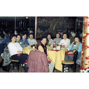 Women pose at a restaurant table during a celebration of the Chinese New Year held by the Chinese Progressive Association