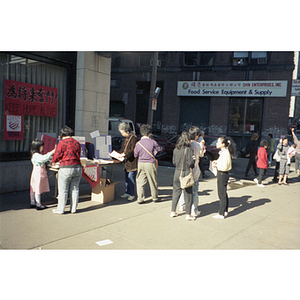 On a street corner in Chinatown, people hand out information about Michael Dukakis and the upcoming presidential election on Nov. 8, 1988