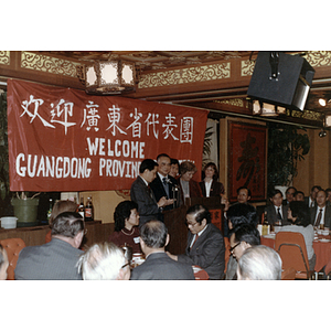 Group stands at a podium during a welcome gathering for the Guangdong Province delegation at Imperial Tea House restaurant in Boston's Chinatown