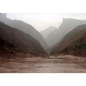 Rows of mountains fade into the background behind a body of water