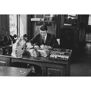 Co-op accounting student counting money at the American Trust Company, Boston