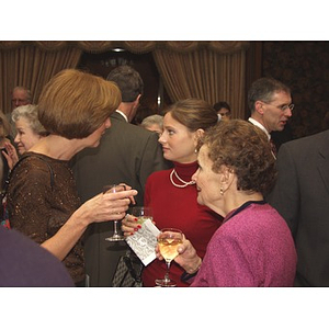 Three women with drinks in their hand before the gala dinner for John Hatsopoulos