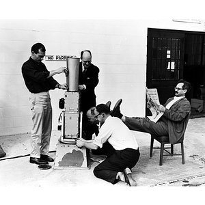 Five men work in an engineering laboratory