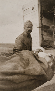Wounded man on a stretcher in front of an ambulance