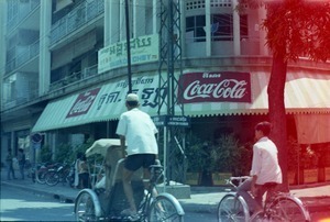 Cafe in downtown, with pedicap and boy on bicycle outside