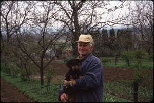 Man with dog, in orchard