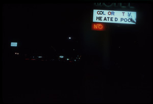 Back-lit motel sign at night: 'color TV heated pool No'