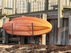 Plastic boat suspended from the side of a wooden deck