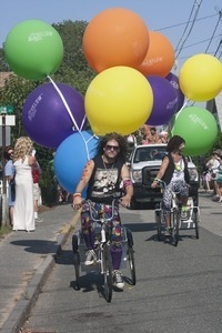 Parade marcher on tricycle, towing large helium balloons : Provincetown Carnival parade