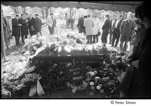 Jack Kerouac's funeral: view of casket at the cemetery, Gregory Corso holding rose (right)