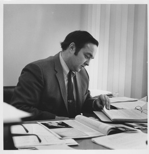 Robert L. Gluckstern sitting indoors, working behind desk
