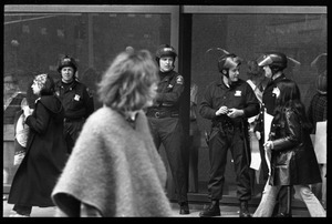 Police watch as antiwar demonstrators picket in front of the John F. Kennedy Federal Building