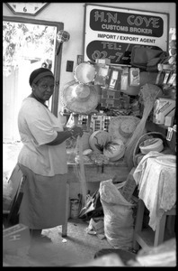 Woman plaiting palm leaf baskets in her store, Belize City