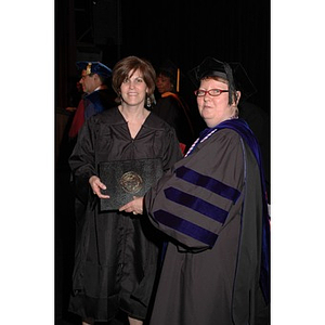 Faculty member presents student with certificate at School of Nursing convocation