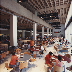 Students eat and study at round tables in the Ell Student Center addition