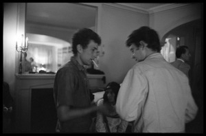 Bob Dylan starting a cigarette with an unidentified man at a reception, Newport Folk Festival