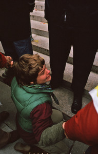 Woman kneels at the feet of the police