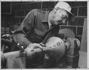 John Ryan working on wooden lamp in carpentry shop