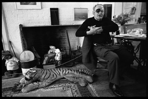 W. Eugene Smith, seated at a desk in his home