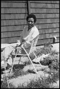 Cuban writer Nancy Morejón, seated in a lawn chair behind a house