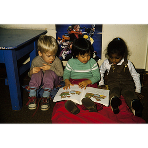 Young children sitting and reading a picture book