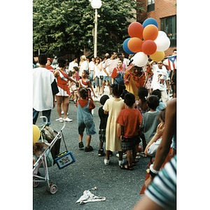 Children cluster around a clown with balloons at Festival Betances.