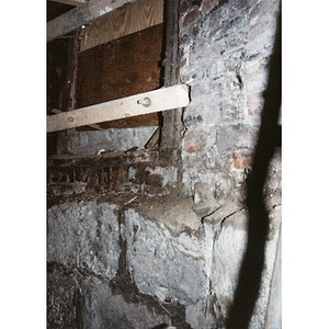 Stone foundation and boarded-up window at 326 Shawmut Avenue, seen from inside the basement.