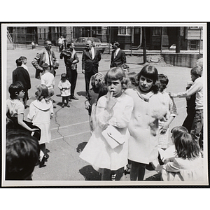 Visitors and several staff members stand and walk outside during a Boys' Club Pet Show