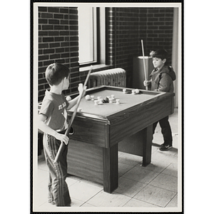 Two boys playing a bumper pool game