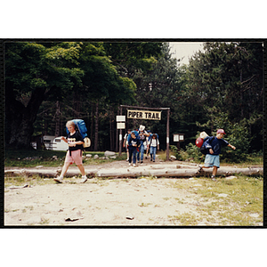 A group of youth with backpacks exit the Piper Trail with their supervisor