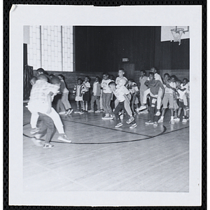 Boys compete in a piggy back race in a gymnasium during Tom Sawyer Day