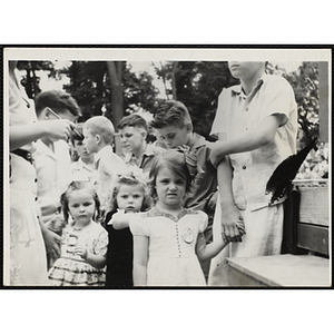 Three girls stand with their brothers while looking at the camera during a Boys' Club Little Sister Contest