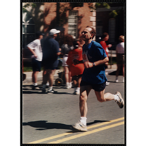 A mans runs past spectators during the Battle of Bunker Hill Road Race