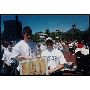 Executive Director Jerry Steimel (right) poses with a man holding a framed print during the Battle of Bunker Hill Road Race