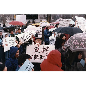 Chinese man, facing front, holding up a sign in Chinese as he participates in a bilingual education rally at the Massachusetts State House
