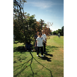 Man and woman stand in a grassy field, in a Vancouver park