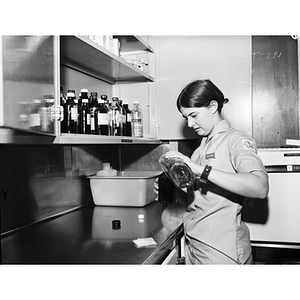 A co-op nursing student measures liquid from a bottle