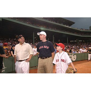 Two men and a boy walk together at Fenway Park
