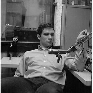 Young man sitting beside microphone in the broadcast booth of the WNEU studio