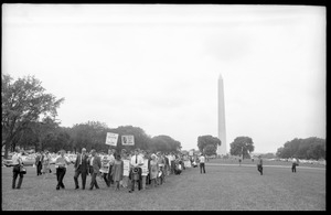 Marchers on the National Mall carrying anti-war signs, heading toward the U.S. Capitol building (Washington Monument in the background)
