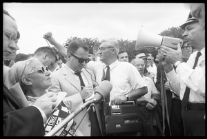 News media and officer with a bullhorn during peace march in Washington