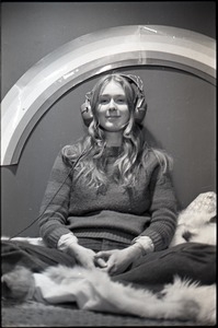 Lynn Smith on a faux fur blanket, modeling Koss headphones