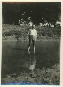 John S. Bailey outdoors, wading in water