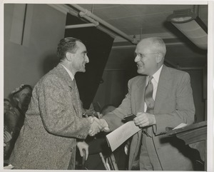 Unidentified man shaking hands with a man using a cane at an ICD event