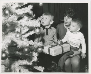 Young boys and woman with presents and Christmas tree