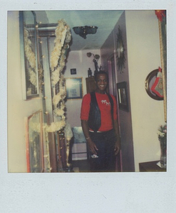 A Photograph of Marsha P. Johnson Smiling in an Apartment with Christmas Decorations