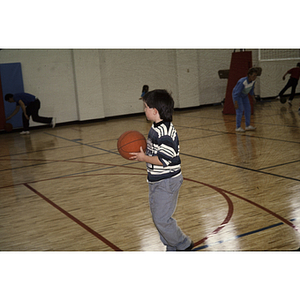 Boy holding basketball in a gymnasium