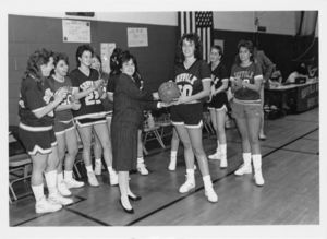 Doreen Matta presents Suffolk University women's basketball player Ellen Crotty with a game ball celebrating her 1,000 career points at Suffolk, 1988
