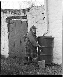 Old woman from Coalisland, Co. Tyrone at water barrel