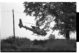 Security forces at Loyalist "home-made arms" factory, The Spa, Ballynahinch, Co. Down. Shots of a Lynx helicopter flying overhead and a police and army road-block outside the building